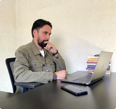 Rodrigo está sentado em frente a um computador em seu momento de trabalho.